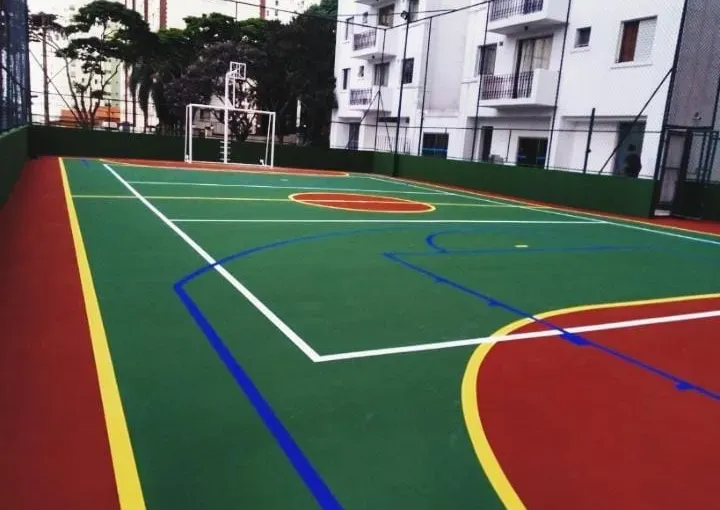 Quadra poliesportiva cercada por edifícios residenciais.