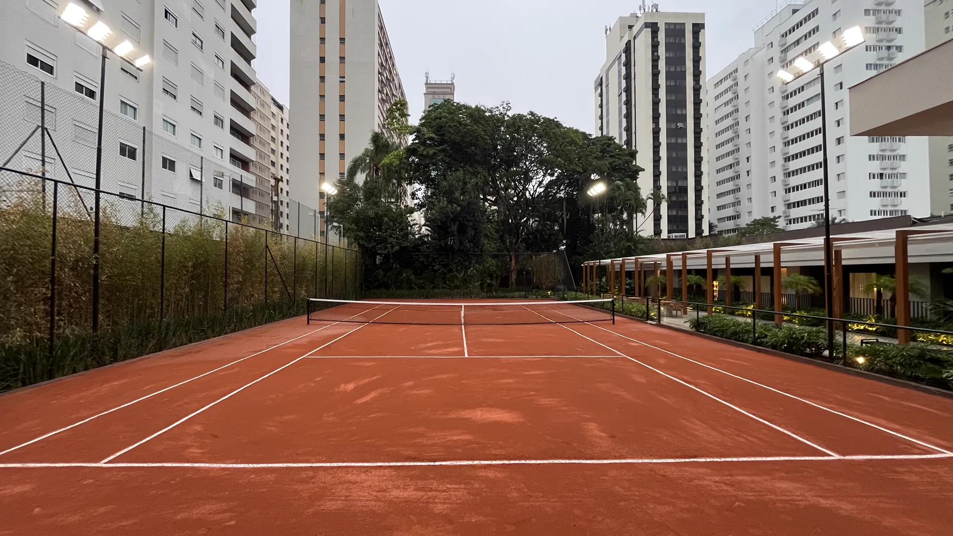 quadra de tênis em saibro com iluminação